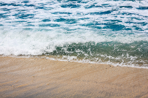 waves and foam of sea water with clear water on one of the beaches on the island of Lombok, Indonesia