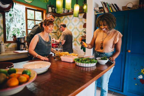 istock Two smiling mature couples making dinner together at home 1996314338