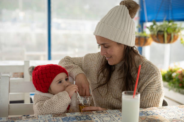 outdoor urban lifestyle. mom and kid in cafe. - childcare centre photos et images de collection