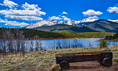 A tree trunk bench against the backdrop of the snow-capped Pikes Peak mountains, Colorado, US