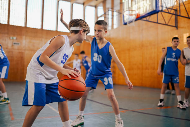 istock A junior team practicing basketball on training at indoor court. 1996395616