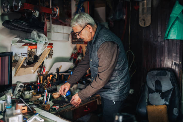 istock An old craftsman is gluing shoes at how workshop. 1996395623
