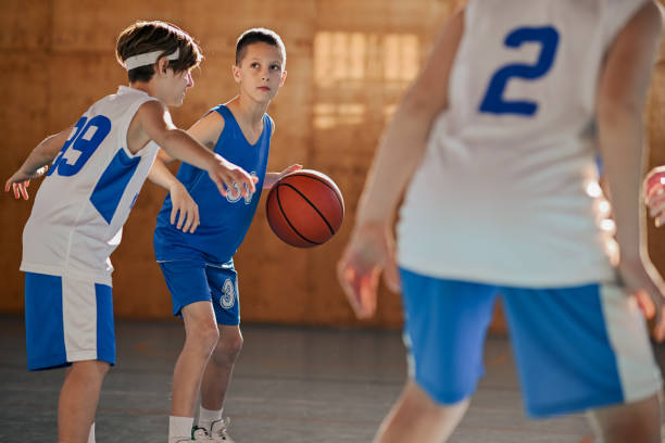 istock Junior basketball team in action practicing basket on training at court. 1996395626