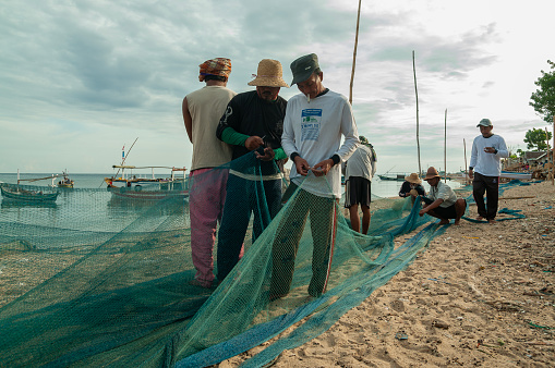 Probolinggo, Indonesia - November 30th, 2014 : The daily activities of villagers on the Gili Islands are repairing fishing nets before they are used for fishing in the sea