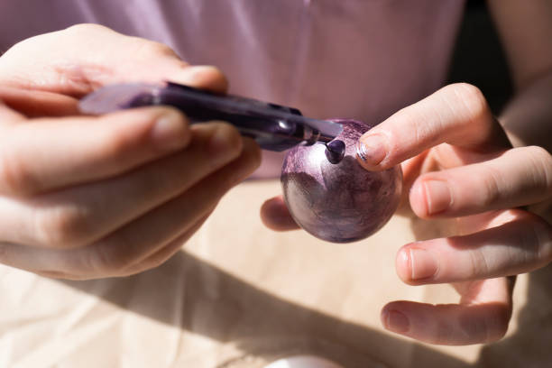 Child paints an Easter egg with a brush