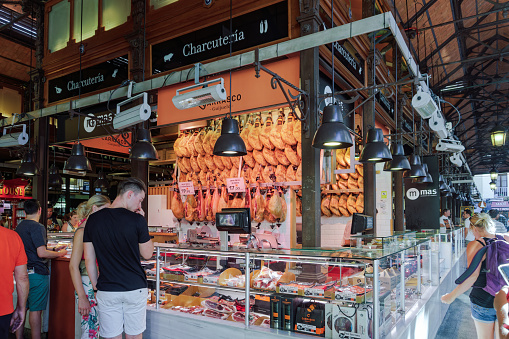 Madrid, Spain - July 22 2017: fresh food market, Mercado de San Miguel interior with Jamon and cold cuts for sale.
