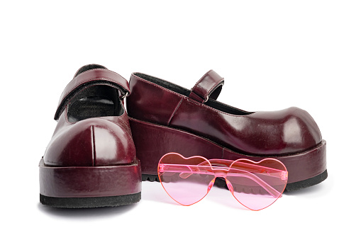 A pair of vintage Y2K chunky shoes and heart shaped glasses isolated on white.