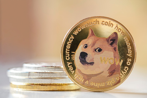 Maesot, Thailand- June 5, 2021:Dogecoin standing in front on bright blurred background, New concept cryptocurrency virtual money is the future of digital currency online financial payments, free copy text space.