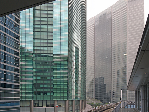 Urban background of Massive skyscrapers glass walls with reflections in Tokyo, view from Yurikamome monorail station Shimbashi