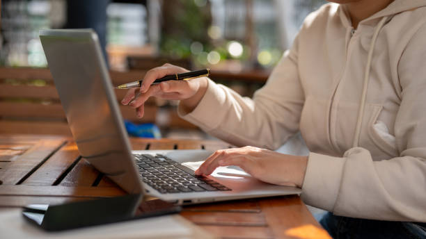 istock A woman working remotely at a cafe, online on her laptop computer, and typing on the keyboard. 1996629879