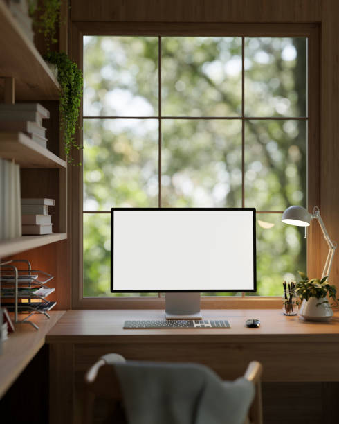 istock Modern vintage and cosy home office workspace with a white-screen computer mockup on a wooden table. 1996639154
