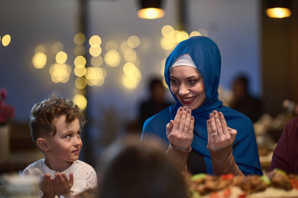 istock In a modern restaurant setting, a European Islamic family comes together for iftar during Ramadan, engaging in prayer before the meal, uniting tradition and contemporary practices in a celebration of faith and family 1996707049