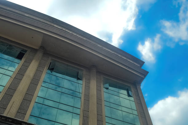 low angle of a modern classic style building with a cloudy blue sky