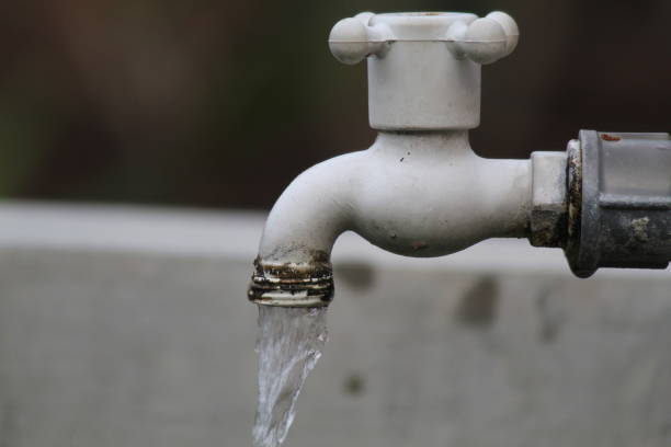 istock Water rushes from a white faucet into a murky pool 1996781821