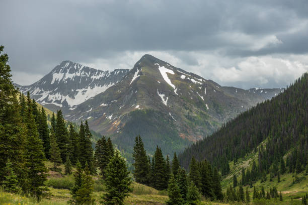istock Snow capped mountains with summer storm clouds 1996963323