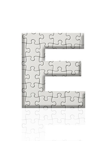 Close-up of three-dimensional blank jigsaw puzzle alphabet letter E on white background.
