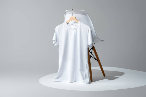 White blank t-shirt hanging on chair in empty room