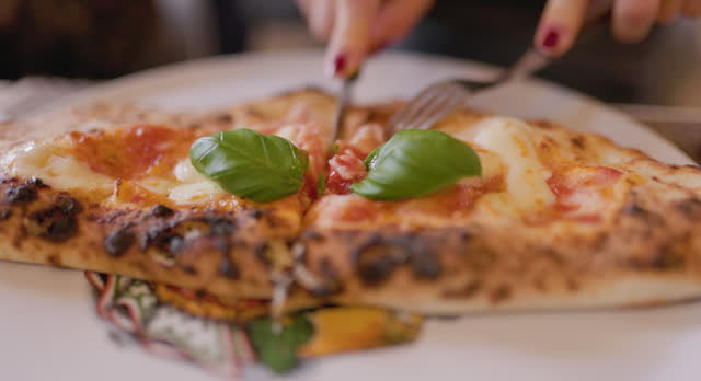 Closeup of teenage girl cutting calzone pizza in a restaurant