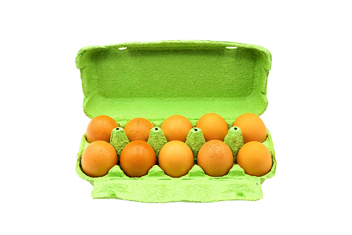Open box with ten whole brown eggs isolated on white background with clipping. Fresh rustic chicken eggs in egg container, close up top view on white background