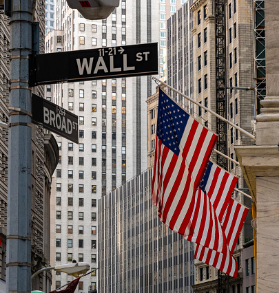 Wall street in New York with American flags