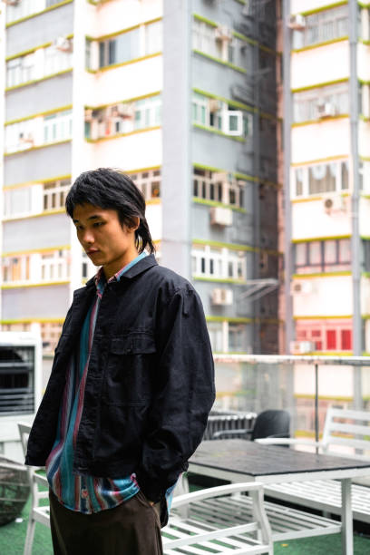 istock Captured in a vertical shot, a young Asian man strikes a pose on a sunny day 1997059051
