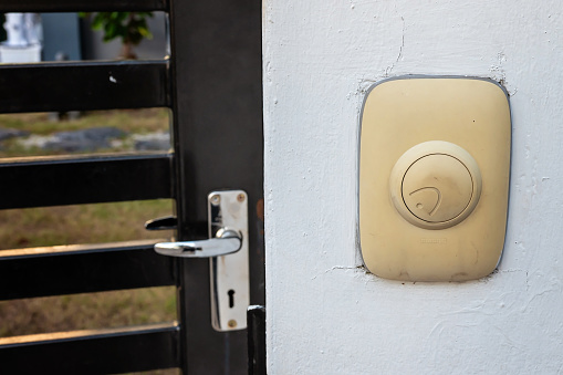 Man's hand opening door into light unknown room of mystery and opportunity. Focus on doorknob and door.