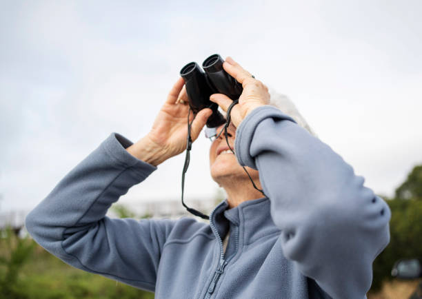 istock Senior woman looking through binoculars during a walk outdoors 1997063333