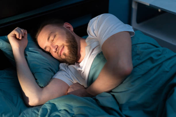 istock Top View of bearded happy man sleeping on comfortable bed in bedroom 1997067526