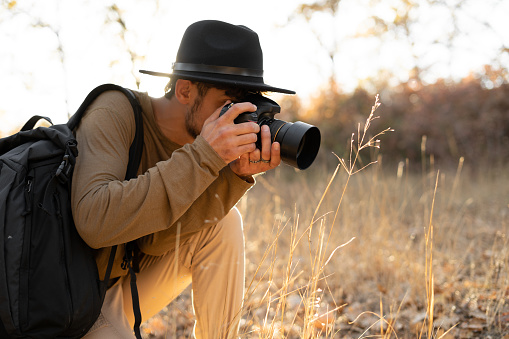 Arabic Photographer with dslr camera shooting nature style pictures in country field. Copy space