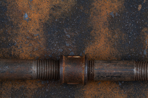 Rusty old metal gear on the background of a rusty iron sheet.