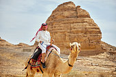 Saudi man in traditional clothing on camel