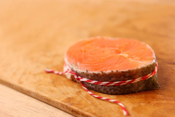 For baking, a piece of salmon is wrapped in a circle and tied with a string