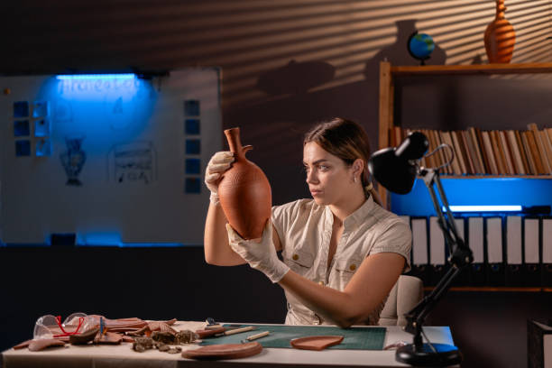istock Archeologist working with old vase late night in office 1997083452