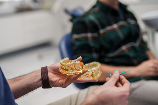 Male dentist with male patient in his clinic.