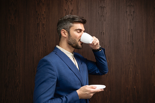 Elegant businessman enjoying cup of coffee.