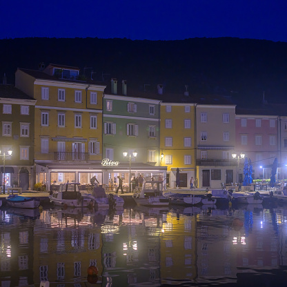 Cres, Croatia - October 24, 2022: The harbor of Cres in the night, misty reflection of colorful houses