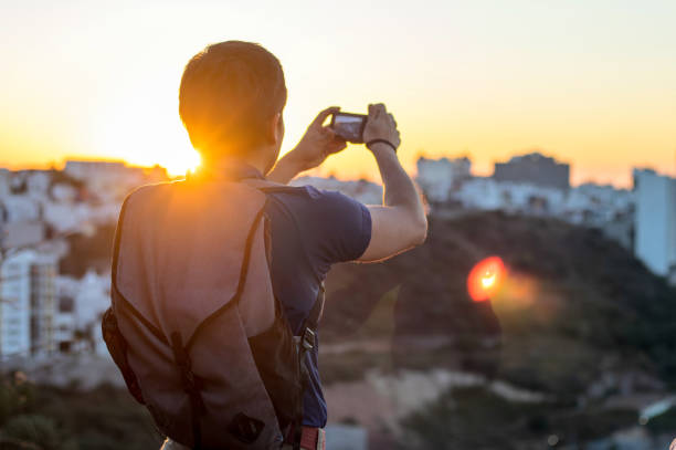 istock Young man taking a photo with his camera at sunset, with space for text 1997186254
