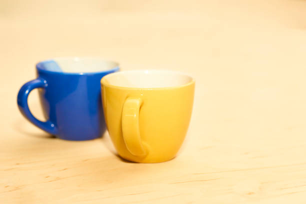 Pattern of yellow coffee cups in a row on blue background