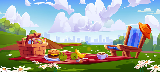 Picnic setup with food on red blanket and in wicker basket at city park over skyline of multistory buildings and clouds. Snacks and hamburger, cup of coffee and fruits on mat, lounge chair with hat.
