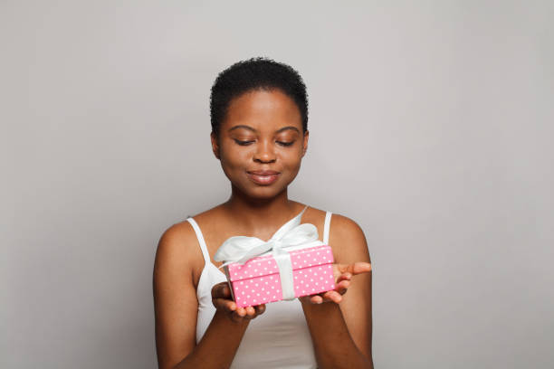 istock Cute happy young woman with gift present box standing on white background 1997227923