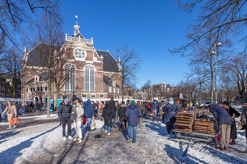 Amsterdam, Netherlands, February 13, 2021; People in the snow at the market in front of the Noorderkerk in Amsterdam.
