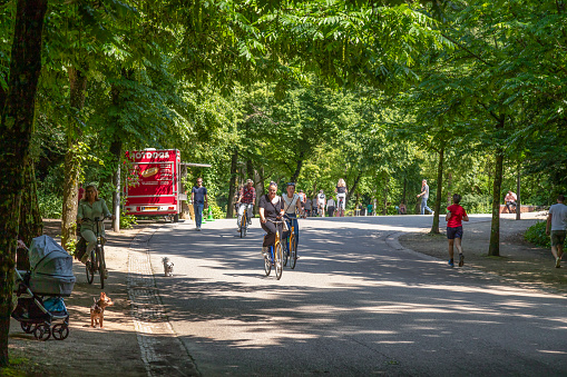 Amsterdam, Netherlands, June 20, 2021; Cyclists and walkers in the Vondelpark in Amsterdam.