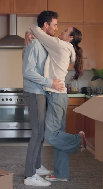 Love, kiss and hug with a couple in their new home together for celebration or real estate investment. Property, mortgage or growth with an excited man and woman embracing while moving house