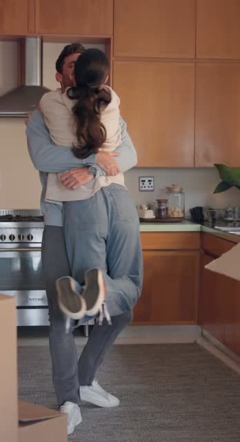 Mortgage, kiss and hug with a couple in their new home together for celebration or real estate investment. Love, property or growth with an excited man and woman embracing while moving house