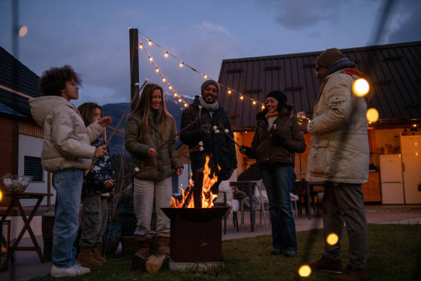 Group of people around fireplace in Julian Alps, Bovec, Slovenia.