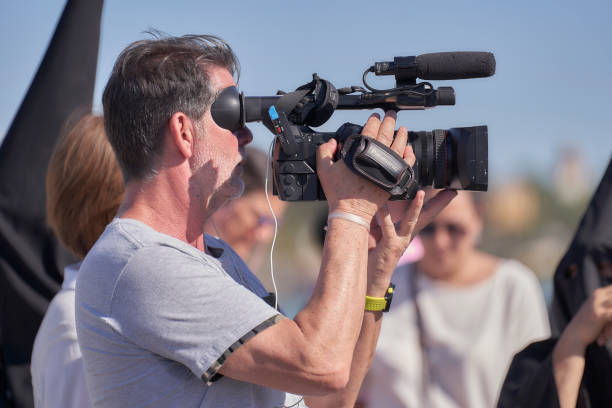 tv camera operator filming semana santa procession on triana bridge - news of the world imagens e fotografias de stock