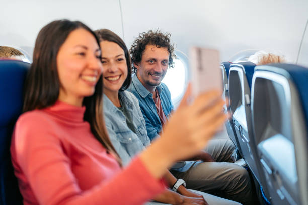 istock Three Young Friends Taking Selfies In An Airplane 1997312593