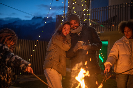 Couple enjoying the outdoors fireplace in Julian Alps, Bovec, Slovenia.