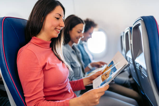 istock Three Young Friends Reading Magazines In An Airplane 1997317910