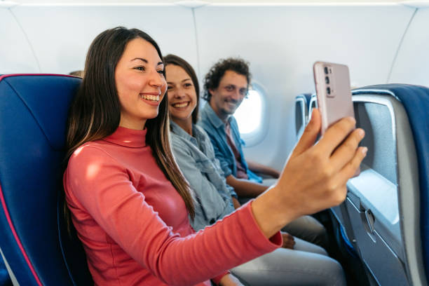 istock Three Young Friends Taking Selfies In An Airplane 1997318967